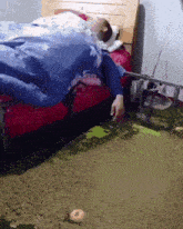 a person laying on a bed with a blue comforter on