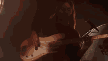 a group of people are singing and playing guitars on a stage
