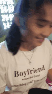 a girl is wearing a white shirt that says boyfriend on it