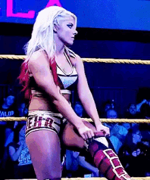 a woman in a wrestling ring with the letter e on her pants