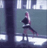 a woman in a pink wig is carrying another woman in a black dress
