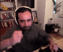 a man wearing headphones is sitting in front of a microphone in a room .