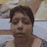 a woman is making a funny face in front of a picture of a man .