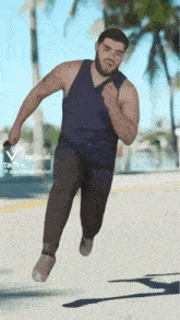 a man with a beard is jumping in the air while wearing slippers .