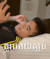 a man is laying on a bed with a foreign language written on the bottom of the image