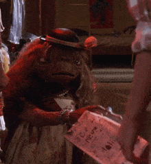 a monkey wearing a hat holds a piece of paper that says " i love you "