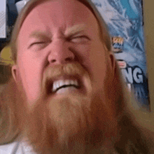 a man with a beard is making a funny face in front of a poster that says viking