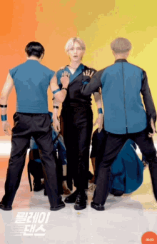 a group of men are dancing in front of a yellow and orange background that says 00:02: