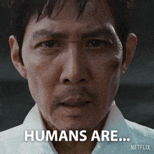 a close up of a man 's face with the words humans are on the bottom right