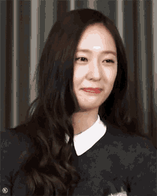 a woman with long hair and a white collar is smiling