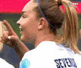 a female soccer player wearing a jersey that says sevennis on it