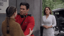 a man in a red uniform is talking to a girl in front of a sign that says prison entrance