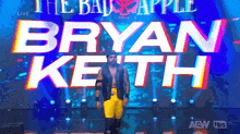 a wrestler is walking on a stage with the name bryan keith on it .