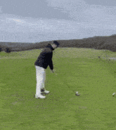 a man is swinging a golf club at a golf ball