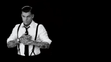 a man in a suit and tie with his hands on his chest .