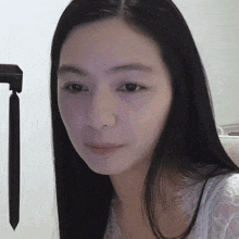 a close up of a woman 's face with a pen in the background