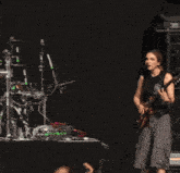 a woman is playing a guitar with a black strap