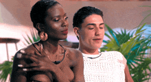 a man and a woman are standing next to each other and the woman has her hand on the man 's chest