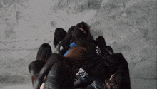 a group of women are hugging each other with one wearing a shirt that says ' a ' on it