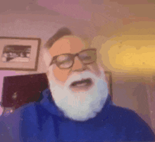 a man with a white beard and glasses is wearing a blue hoodie