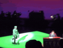 a man is riding a scooter on a stage in front of a crowd