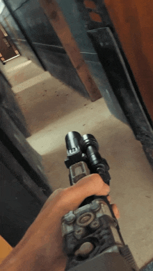 a person is holding a gun with a flashlight attached