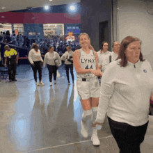 a woman wearing a lynx jersey walks through a crowd