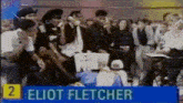 a group of people are gathered in front of a sign that says eliot fletcher