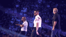 a group of men are standing in front of a crowd with a purple background