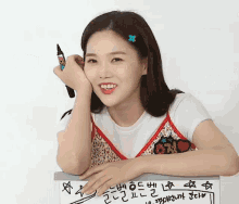 a woman leans against a white board with a marker on it