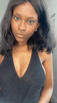 a woman wearing a black sweater has a nose ring