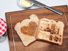 two slices of toast on a wooden cutting board one of which says " real red " on it