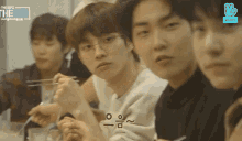 a group of young men are sitting at a table eating .