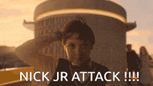 a young boy salutes in front of a building with the words nick jr attack !!! below him