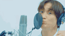 a man wearing headphones and a sony microphone making a face