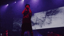 a man singing into a microphone on a stage with the letter d in the lower right corner