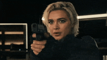 a woman is pointing a gun at the camera with the words " fuck you " below her