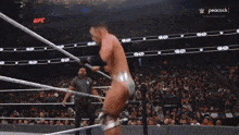 a man in a wrestling ring with peacock 's on the bottom left