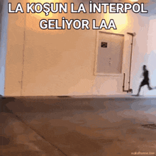 a gif of a person running in front of a wall that says la kosun la interpol geliyor laa