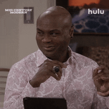 a man with a ring on his finger is sitting in front of a hulu ad