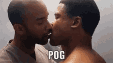 two men are kissing each other with the words pog written on the bottom of the image .