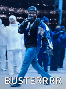 a man in a blue jacket stands in front of a crowd with the word busterrr written on the bottom