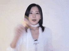 a woman wearing a white sweater and a white choker is making a funny face .