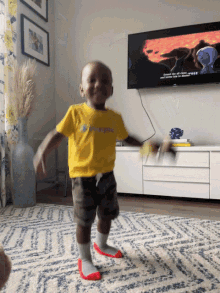 a little boy wearing a yellow shirt that says champion