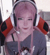 a girl with pink hair and headphones is sitting in a chair .