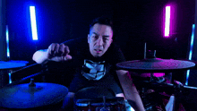 a man with a tattoo on his arm is playing a drum set
