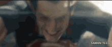 a close up of a man 's face with the words samani tech on the bottom right