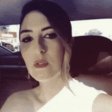 a woman is sitting in the back seat of a car and making a funny face