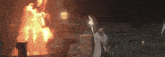 a man holding a torch stands in front of a burning building