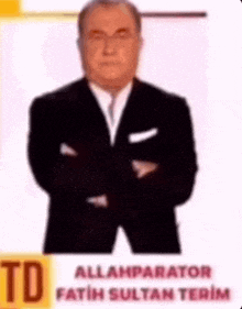 a man in a suit and tie is standing with his arms crossed and his name is allahparator fatih sultan terim